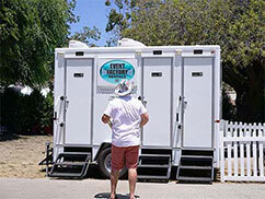 Man standing in front of Clotho luxury restroom trailer rental from Event Factory Rentals.