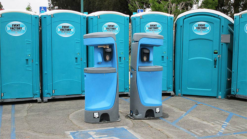 A row of blue portable toilets with blue hand wash stations in front, some of the best portable bathrooms for rent near Piedra, California.
