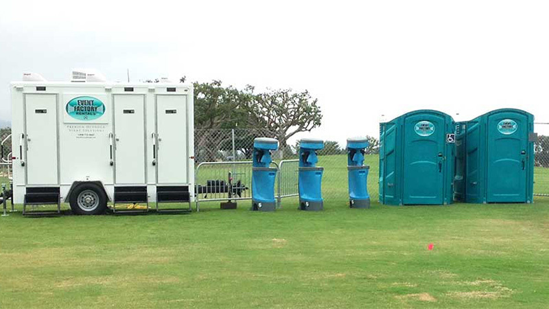 Piedra portable restroom rentals including a luxury restroom trailer, three hand wash stations and two handicap porta potties on a grass field.