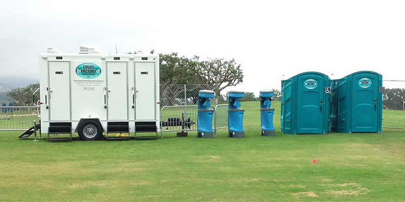 A luxury restroom trailer alongside three handwash stations and two ADA compliant toilets, some of our portable toilet rentals for film production near Lemonwood Eastmont, Oxnard, California.
